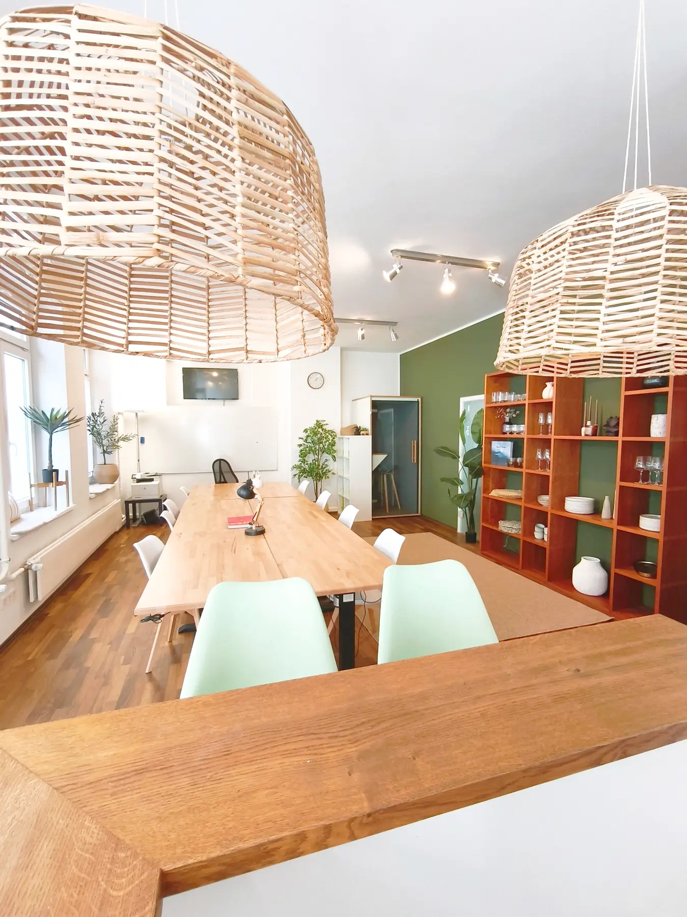 Workshopraum mit Bar, langer Tafel und Call Box im Hintergrund
